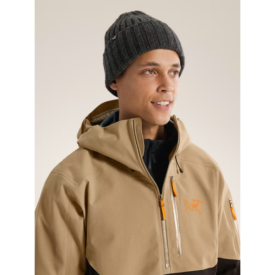Man wearing Arc'teryx Chunky Ribbed Toque in Black Heather with beige winter jacket